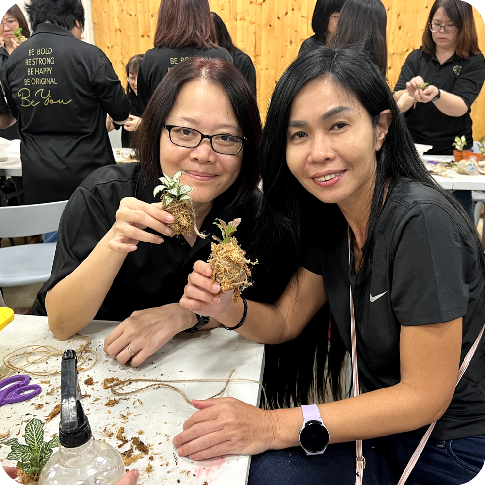 Colleagues showing the plants they made during a hands-on sustainability workshop